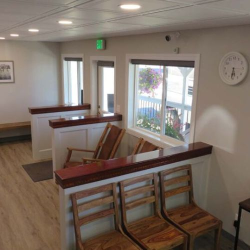 A waiting room featuring wooden benches and a wall clock