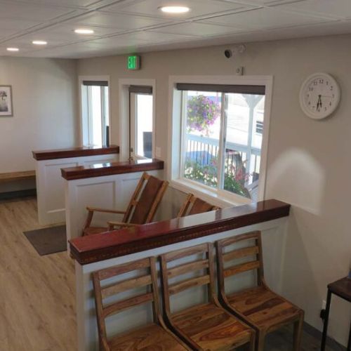 A waiting room featuring wooden benches and a wall clock